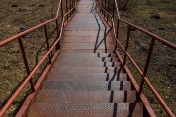 a pedestrian staircase pointing up against the sky where there are no people on the steps