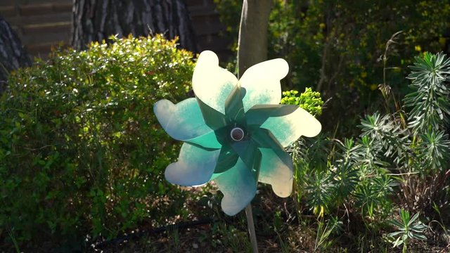 moulin &agrave; vent tournant dans le mistral sur fond de jardin vert en Provence