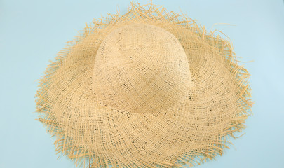 Summer concept of straw hat on isolated blue background