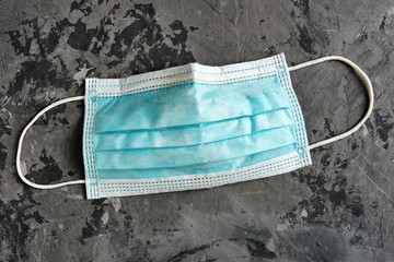 used protective masks closeup on gray concrete background. Covid-19 quarantine. Flat lay, top view, closeup