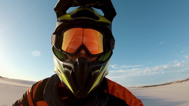 Shot from helmet mounted action camera of professional dirt bikers practising in desert. Motorcylists doing off roading on sand dunes.
