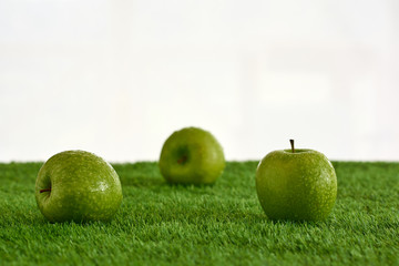 
Apples on a green lawn and a white background.