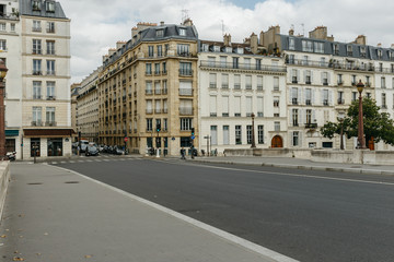 Fototapeta na wymiar Typical old Paris architecture and deserted streets with no tourists while citizens stay at home in self isolation. Residential buildings facades, expensive real estate concept, economy crisis