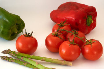 
Tomatoes, red pepper, green pepper asparagus on a white background.