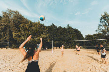Naklejka premium Junge Frau macht Angabe beim Beachvolleyball