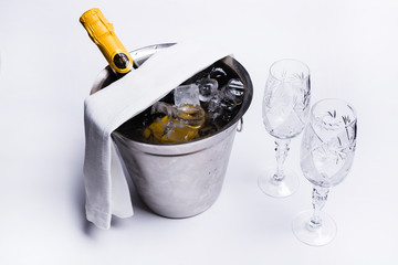 champagne in an ice bucket and two glasses