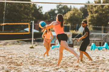 Freunde spielen zusammen Beachvolleyball