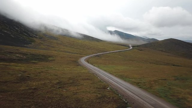 Two hitchhikers in the stormy weather of the Dempster Highway in Northern Yukon