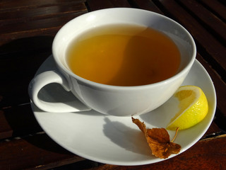 Cup of fresh herbal tea and lemon close up.