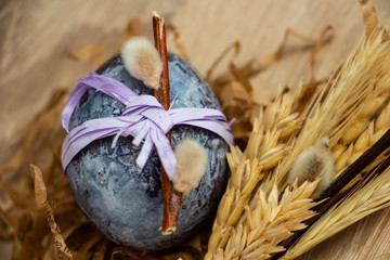 one beautiful easter egg and a bouquet of spikelets on a wooden background
