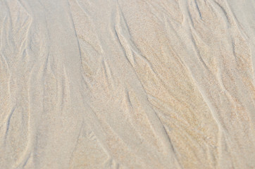 Fototapeta na wymiar Sand along the sea is a blurred patterned background.