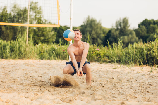 Junger Mann am Hechten beim Beachvolleyball