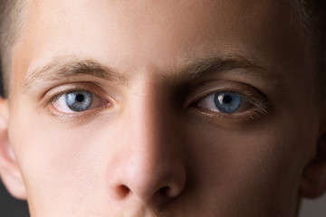 Portrait of a guy close up looking at the camera with blue eyes