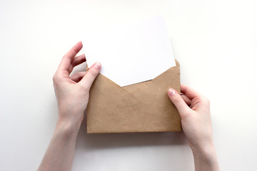 Envelope and white empty letter mock-up in female hands top view. Communication, information, post,...