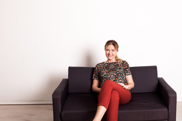 portrait of a beautiful woman of forty years on an office black sofa