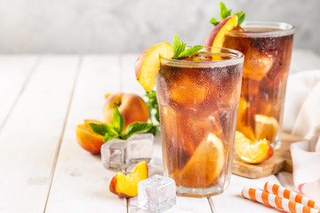 Iced tea and ingredients in glasses on wood background, copy space