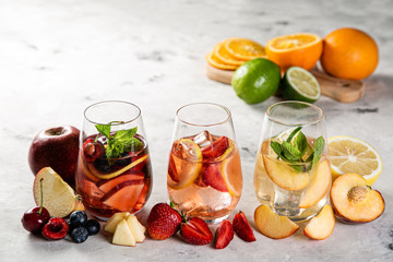 Selection of sangrias - red, pink, white and ingredients, rustic background