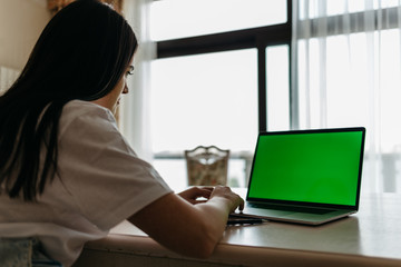 Over The Shoulder View Of Woman Lying On Sofa Using Green Screen Laptop