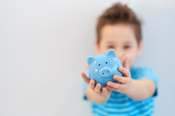 Fototapeta na wymiar little asian boy holds a piggy bank in his hands. money saving concept
