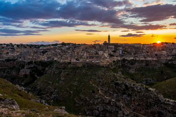 Fototapeta premium Amazing distant sunset panoramic view of Matera from Parco della Murgia Materana or Park of the Rupestrian Churches of Matera in the Province of Matera, Basilicata Region, Italy