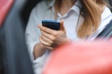 woman with mobile phone in car