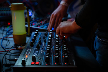 dj is mixing tracks at party in night club. disc jockey playing music on the modern turntable close...
