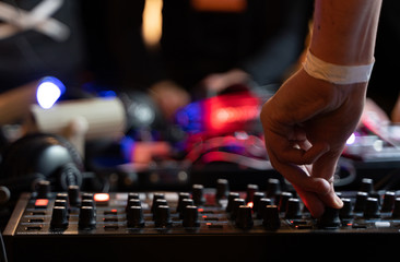 dj is mixing tracks at party in night club. disc jockey playing music on the modern turntable close...