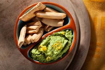 Peas spread with lemon and bread sticks for dipping seen from above