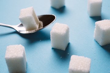 Sugar cube on a blue background shot on macro. Teaspoon sugar