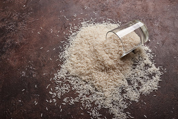 white basmati rice in a glass cup on a brown background