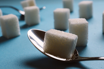 Sugar cube on a blue background shot on macro. Teaspoon sugar