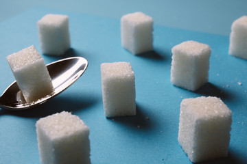Sugar cube on a blue background shot on macro. Teaspoon sugar
