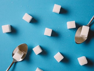 Sugar cube on a blue background shot on macro. Teaspoon sugar