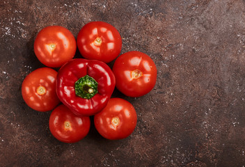 fresh tomatoes and peppers on a brown background isolated
