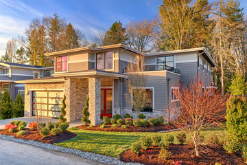 Fototapeta na wymiar Modern contemporary house exterior with luxury details, landscaping, stone, wood, glass, lots of large windows.