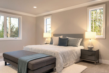 Large luxury modern bedroom interior with grey walls and white rug, large windows.