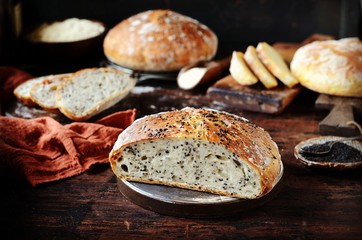 Homemade bread assortment: corn, with sesame seeds and chia seeds on a dark wooden background. rustic