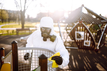 Man wearing protective suit washes and disinfecting the playground to preventing the spread of the epidemic of coronavirus, pandemic in quarantine city. Covid -19. Cleaning and Disinfection.