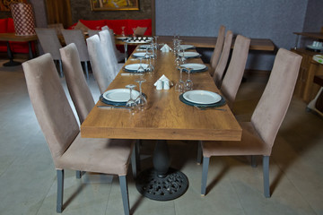 Set of a dish with spoon, fork and knife on wooden table. Empty Table setting on woo den table in restaurant served for dinner . Brown chare