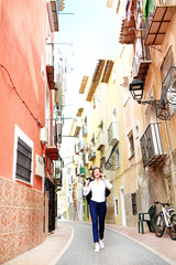 Solitary walk around the city.  A woman is walking through the empty streets of the city talking on the phone