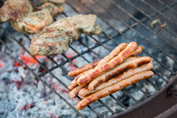 grilled meat on the grill with the stack of sausages