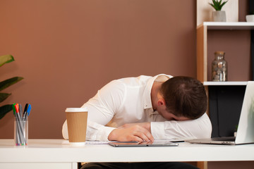 Tired employee working at desk at company office