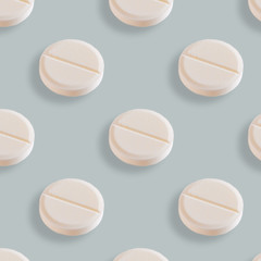 Medical seamless pattern made with white pills on blue background.