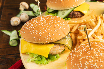 burgers with french fries on the wooden background