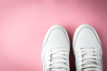 White sneakers on pink background.