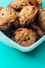 Chocolate cookies handmade on a plastic pot isolated on a green background