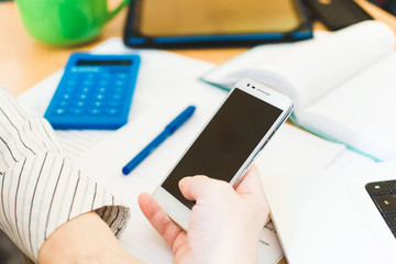 Social distancing protect coronavirus or covid-19. Closeup woman using white mobile phone. Female working in workplace at home. Teacher teaches remotely. Online education and distance work concept.