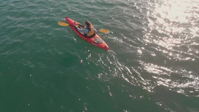 Aerial view of a kayaker rowing a kayak.
