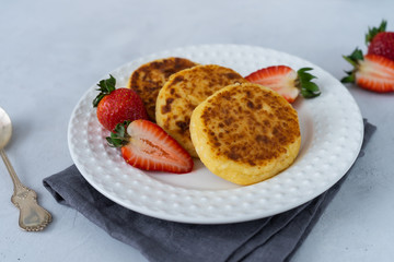 Cheesecakes for breakfast with berries on a white plate
