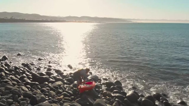 A kayaker entering the ocean.
